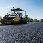 Worker,Operating,Asphalt,Paver,Machine,During,Road,Construction,And,Repairing