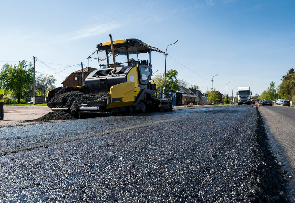 Worker,Operating,Asphalt,Paver,Machine,During,Road,Construction,And,Repairing